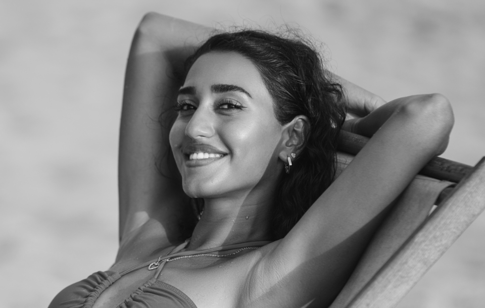Woman reclining confidently in a chair, showcasing refreshed skin.