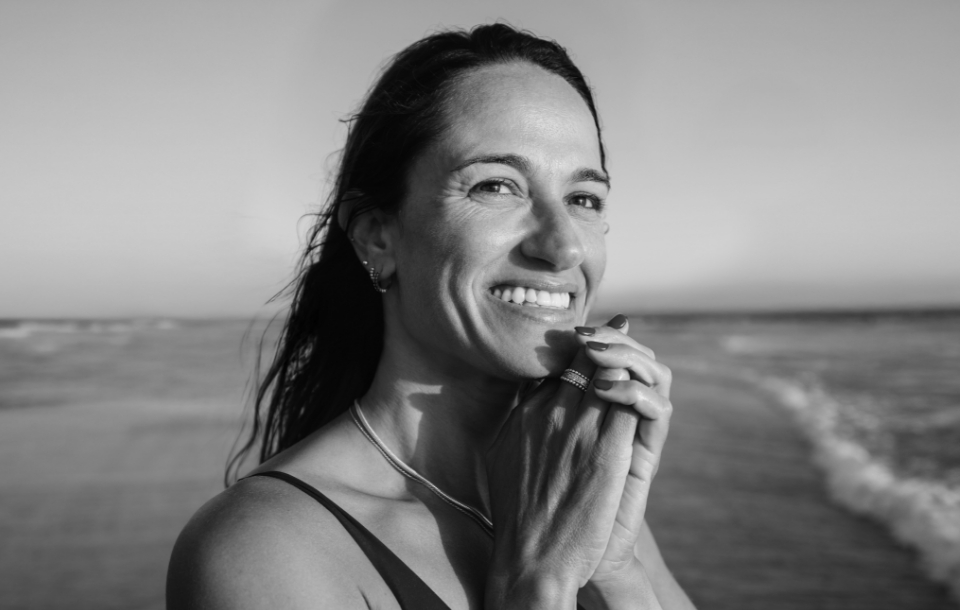Woman smiling confidently at the beach.